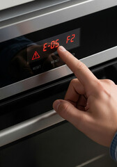 Obraz premium Digital display of an appliance showing an error code, with a human hand about to troubleshoot it
