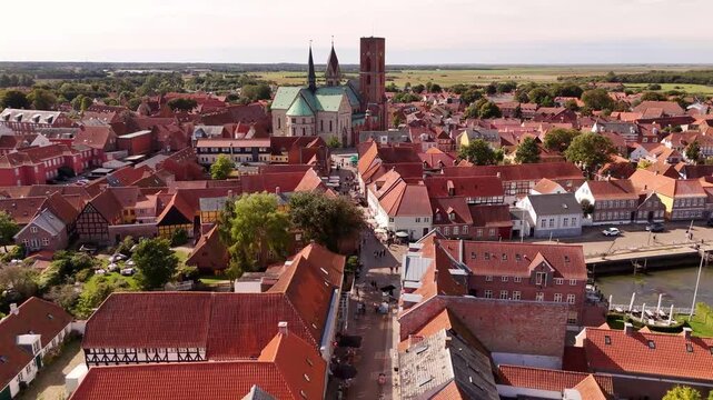 Aerial view of the historic Ribe Cathedral surrounded by a sea of red-tiled roofs and charming streets, a tapestry of old-world charm, Ribe, Denmark.