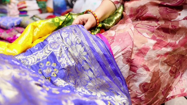 colorful indian traditional saree selection by customer at retails shop