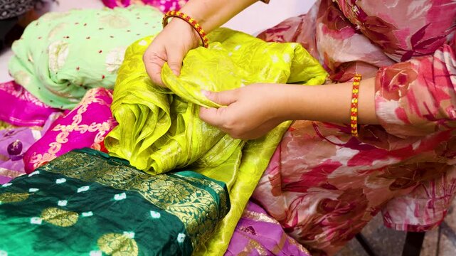 traditional indian saree selection by customer at market by touching the texture