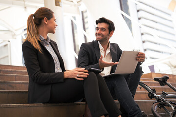 Commuting to work with bicycle. Businessman businesswoman cycling to office in downtown district....