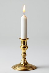 A single white candle in a gold-colored candlestick against a plain gray background.  The candle flickers gently, casting a warm light. The candlestick has a classic, ornate design