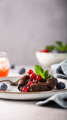 Rich chocolate dessert garnished with vibrant berries and mint leaves, elegantly presented on a plate, showcasing culinary artistry, stories templates with copy space