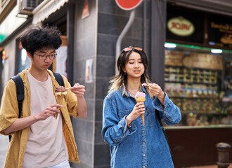 Portrait of a smiling couple in the city, tourists visiting destination, summer trip exploring and eating an ice cream