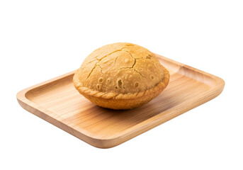 Golden-brown, crispy pastry pie sits atop a light-brown wooden tray against a stark black backdrop.