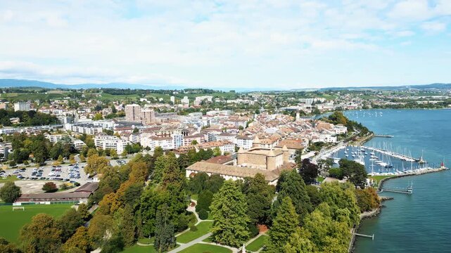 Aerial view of Morges, featuring a marina filled with sailboats, set against the backdrop of the city's architecture, Morges, Vaud, Switzerland.