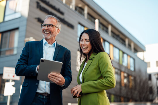 Business team collaborating with tablet outside clinic building