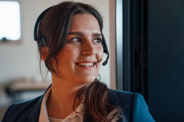 Businesswoman with headset smiling in office customer support role