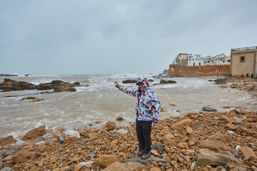 A tourist on the shore of the Atlantic Ocean in Morocco. Photographed against the background of the...