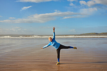 Fototapeta premium A girl on the shores of the Atlantic Ocean enjoying the sunrise. Morocco