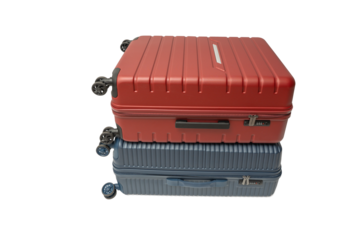 A red suitcase stacked on a blue suitcase with wheels on a transparent background in PNG format. Both are hard-shell travel luggage.
