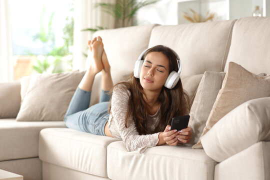 Woman relaxing listening streaming audio from headphone - Powered by Adobe