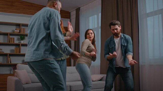 Four multiracial friends ethnic diversity buddies people dancing at home party multiethnic men women together dance to music active moving having fun funny celebrate event relocation holiday weekend