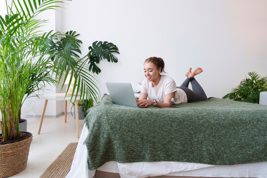 Freelancer with diabetes using laptop lying on bed at home