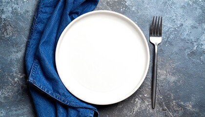 Empty white plate on a textured surface with a napkin