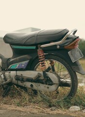 Side View of Retro Vintage Japanese Cub Motorcycle in Countryside View with Classic Warm Tone Photo