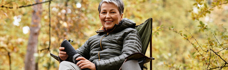 Senior woman enjoying a peaceful break while hiking in a vibrant forest trail