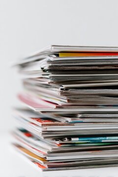 A stack of magazines, various colors and shades of paper, tightly bound together