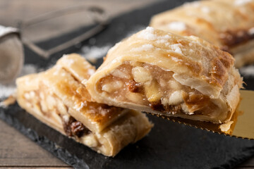 Homemade apple strudel slice on wooden table