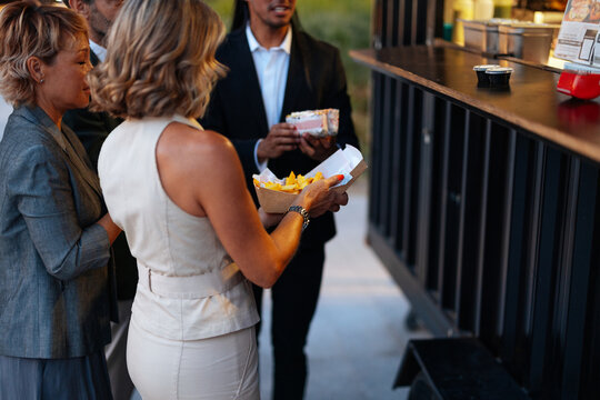 Business people enjoying street food from a food truck - Powered by Adobe