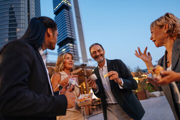 Businesspeople enjoying street food after work in Madrid