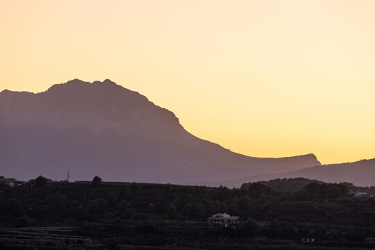 Sonnenaufgang &uuml;ber den Bergen zwischen Benitaxell und Teulada mit Blick auf Calpe in Spanien