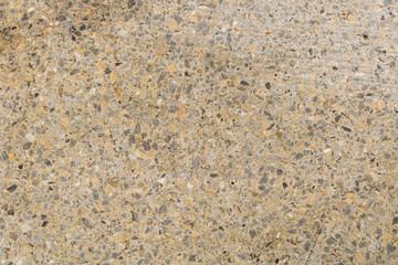 A detailed, abstract background of a road surface, showing a textured background of mixed-color gravel and pebbles.