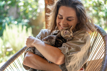 Woman holding little tabby gray kitten