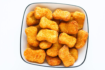 A generous serving of crispy, golden-brown chicken nuggets on a white plate, perfect for a quick snack or meal.