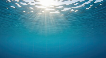 Sunlight filtering through clear blue ocean water from below the surface.