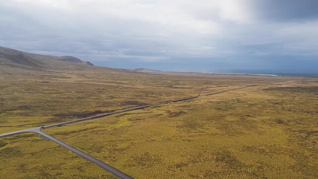 Aerial view of the road cutting through the expansive landscape near Saxh&oacute;ll Crater, with a car visible on the road, Sn&aelig;fellsb&aelig;r, Iceland.
