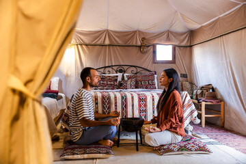 Couple meditating in boho Moroccan tent interior with mindfulness vibe