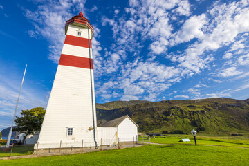 Alnes lighthouse at God&oslash;ya island with mountain behind it, near &Aring;lesund, Norway