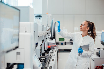 Scientist in lab coat using touchscreen and tablet in modern laboratory