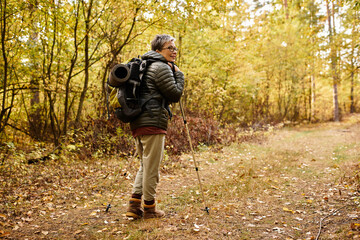 Joyful journey through the autumn forest with a senior womans adventurous spirit
