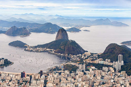 Aerial panoramic view from Cristo Redentor of Rio de Janeiro cityscape and Guanabara Bay, featuring the iconic Sugarloaf Mountain. Brazil - Powered by Adobe