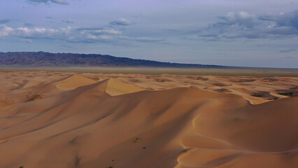 Aerial view of sand dunes in desert at sunset