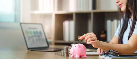 Budgeting: Woman Depositing Coins into Piggy Bank