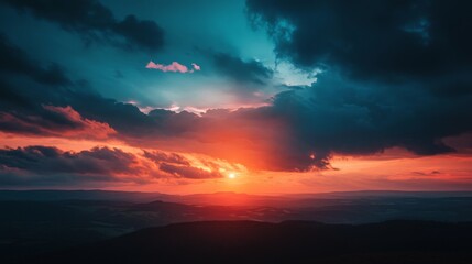 A vibrant sunset paints the sky with hues of orange, red, and blue, casting long shadows over the rolling hills below.