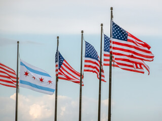 A series of Chicago and American flags fly side-by-side, symbolizing the intertwined patriotism and civic pride of a major city and its nation.