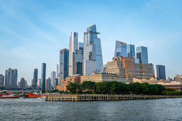 Obraz premium Modern skyscrapers of Manhattan against clear blue sky. Tall modern skyscrapers of Manhattan rise against the backdrop of a clear blue sky.
