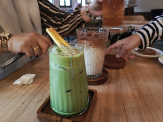 Refreshing Iced Matcha Latte with Garnish During a Social Cafe Gathering