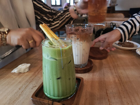 Refreshing Iced Matcha Latte with Garnish During a Social Cafe Gathering - Powered by Adobe