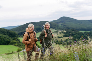 Mature daughter and her mom on hiking trip in nature.