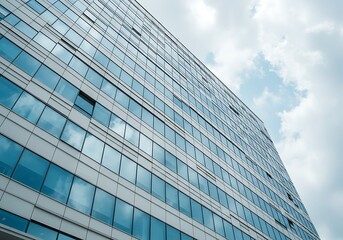 Modern glass building facade with geometric patterns and sky