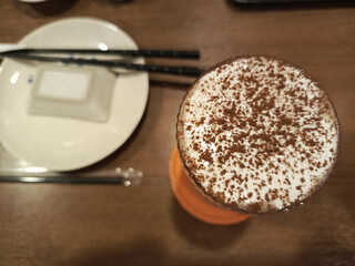 Cocoa-Dusted Froth: A Warm Drink Beside Chopsticks in an Asian Eatery