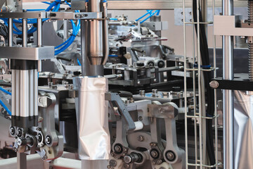 Conveyor belt packs food products in plastic bags, industrial concept background.