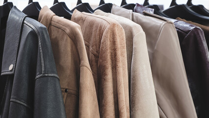 A row of clothes hanging on a hanger, the clothes are of different colors and textures, and all...