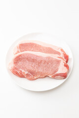 皿に乗った豚ロース肉　白バック