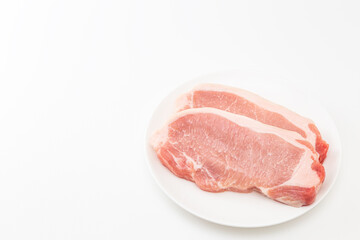皿に乗った豚ロース肉　白バック
